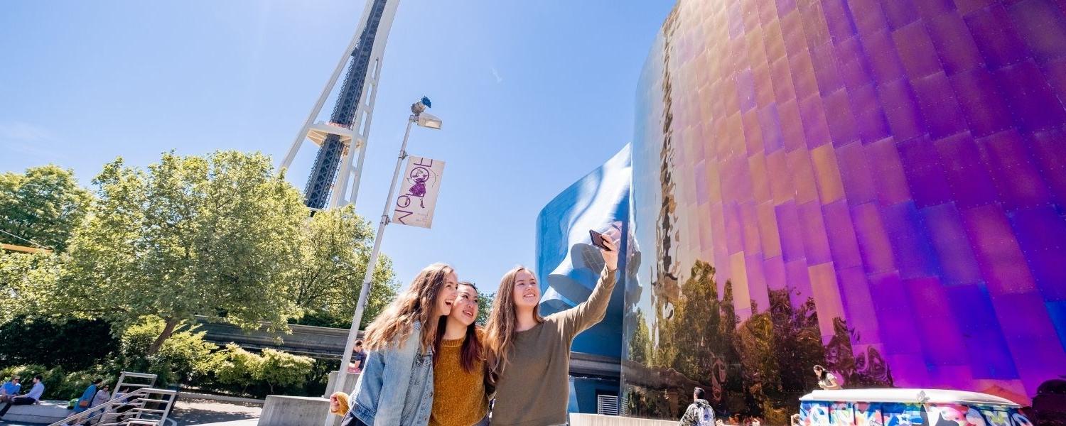 Three SPU students take a selfie near the Seattle Center.